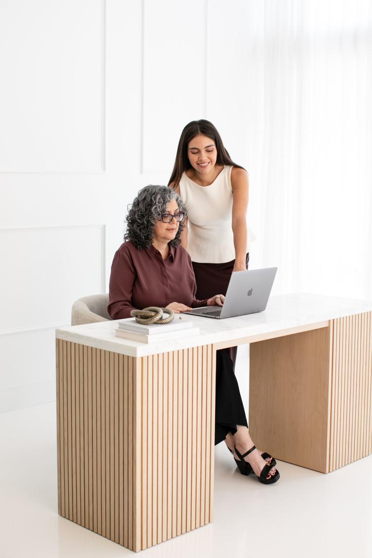 Maria Del Sol and Emily Eidam reviewing a closing order on a laptop